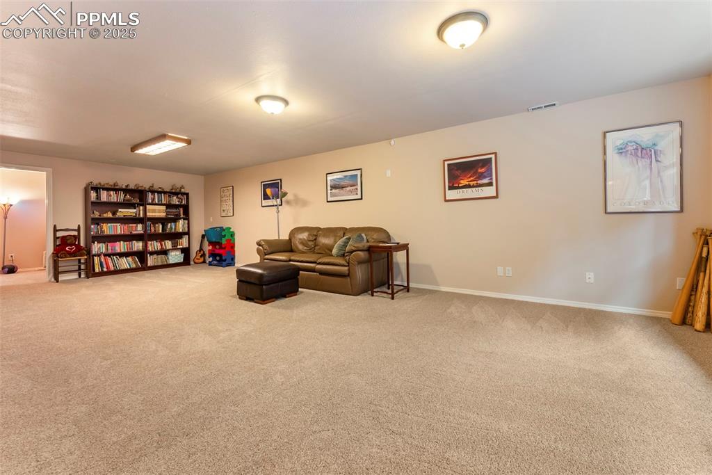 Image 38 of 50: Basement sitting room with light carpet and baseboards