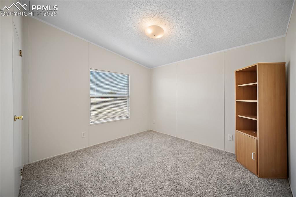 Image 26 of 34: Bedroom #2 with new carpet and vaulted ceilings.