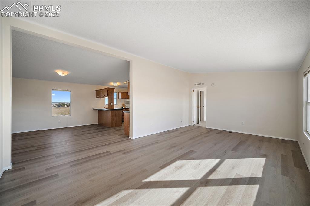Image 6 of 34: Living room with new laminate flooring, vaulted ceiling and open to the din
