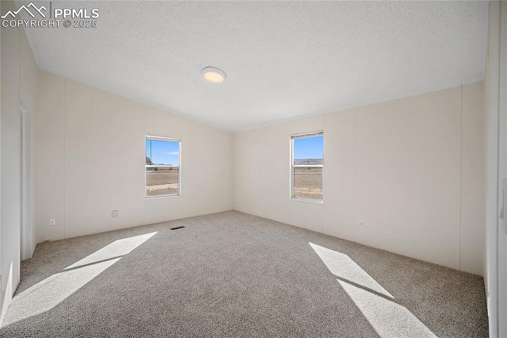 Image 9 of 34: Primary bedroom with vaulted ceiling and new carpet. 