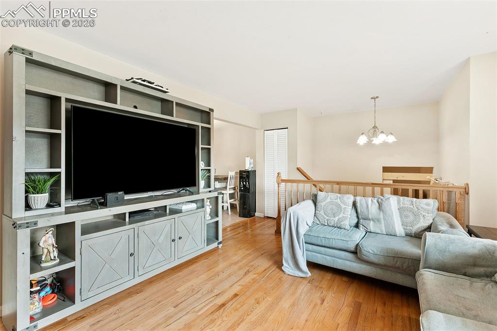 Image 10 of 38: Living area with a chandelier and light wood-style floors