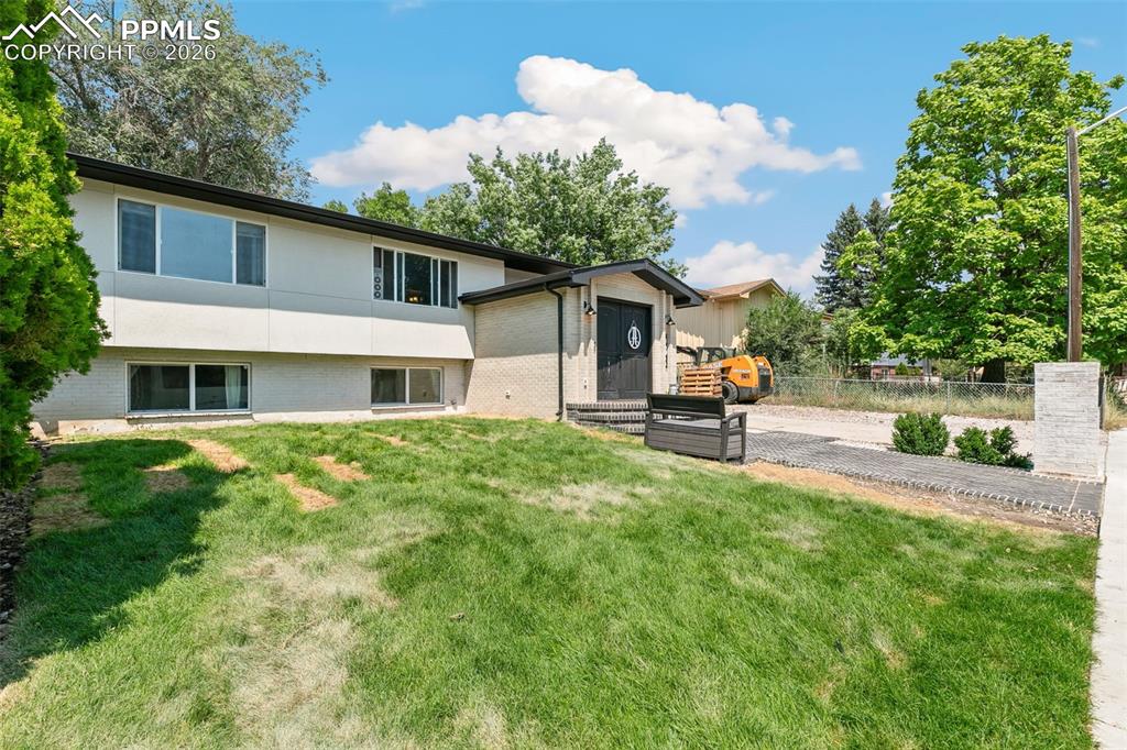 Image 2 of 38: Rear view of house featuring brick siding and stucco siding