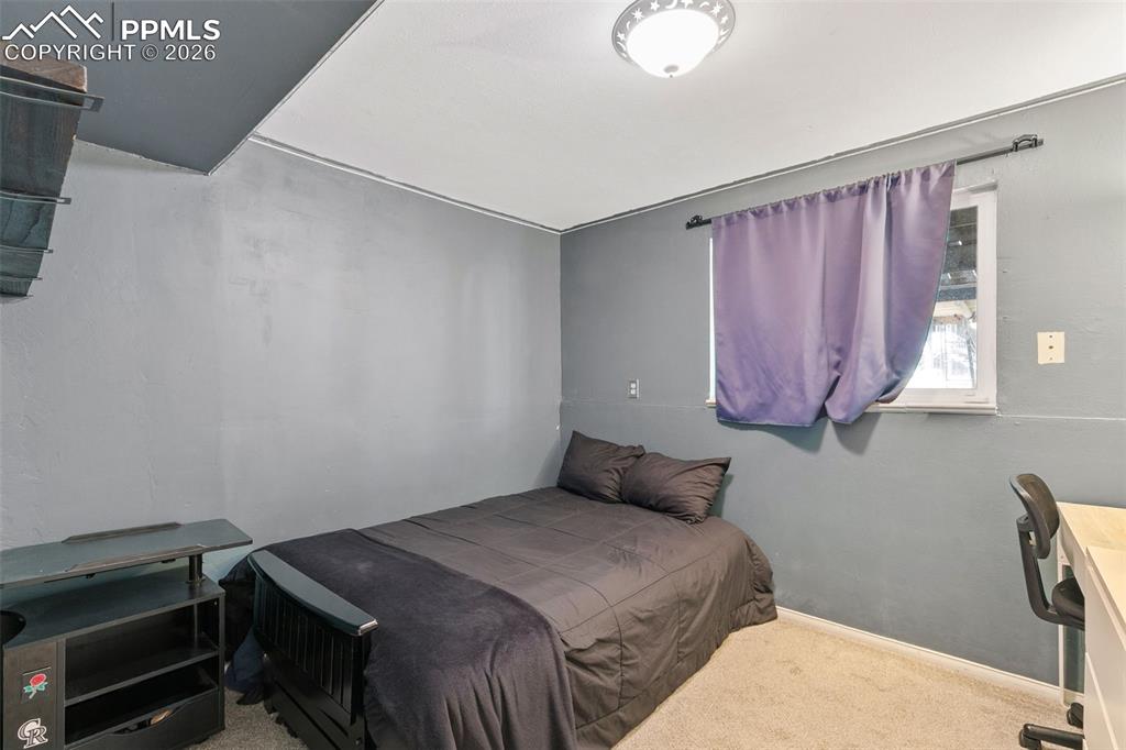 Image 26 of 38: Bedroom with carpet flooring and an office area
