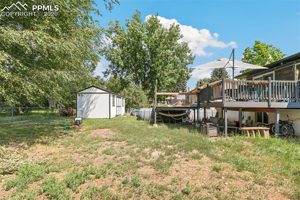 Image 36 of 38: View of yard featuring a wooden deck and an outbuilding