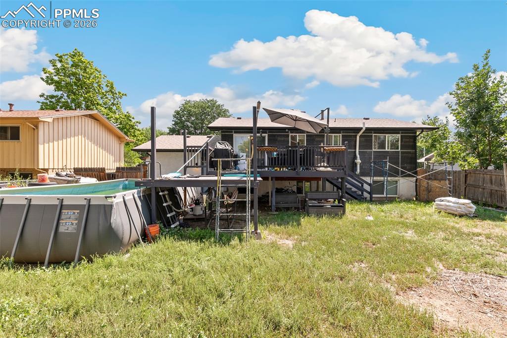 Image 38 of 38: Back of property featuring a deck, a fenced backyard, and stairs