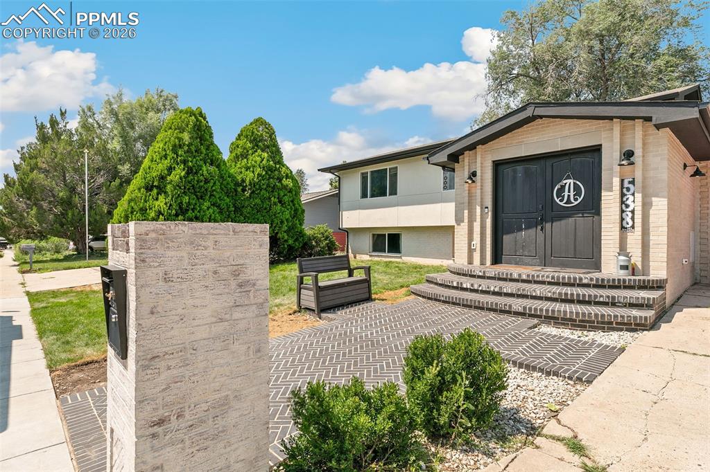 Image 4 of 38: View of front of house featuring brick siding
