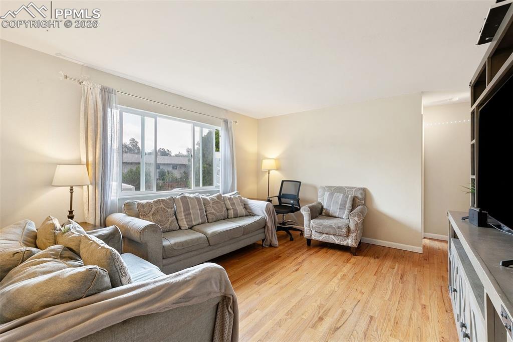 Image 7 of 38: Living room featuring light wood finished floors and baseboards