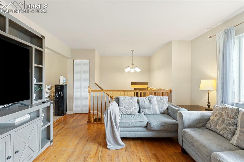 Image 9 of 38: Living area featuring a chandelier and light wood finished floors