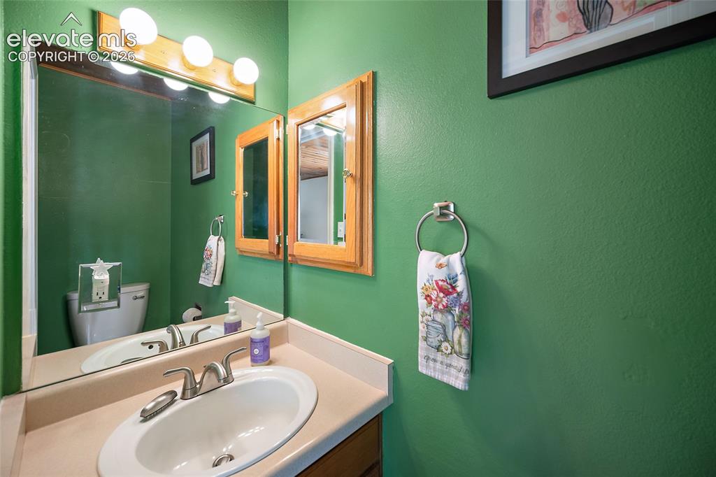 Image 12 of 44: Bathroom vanity featuring an integrated sink, dual-handle faucet, and surfa