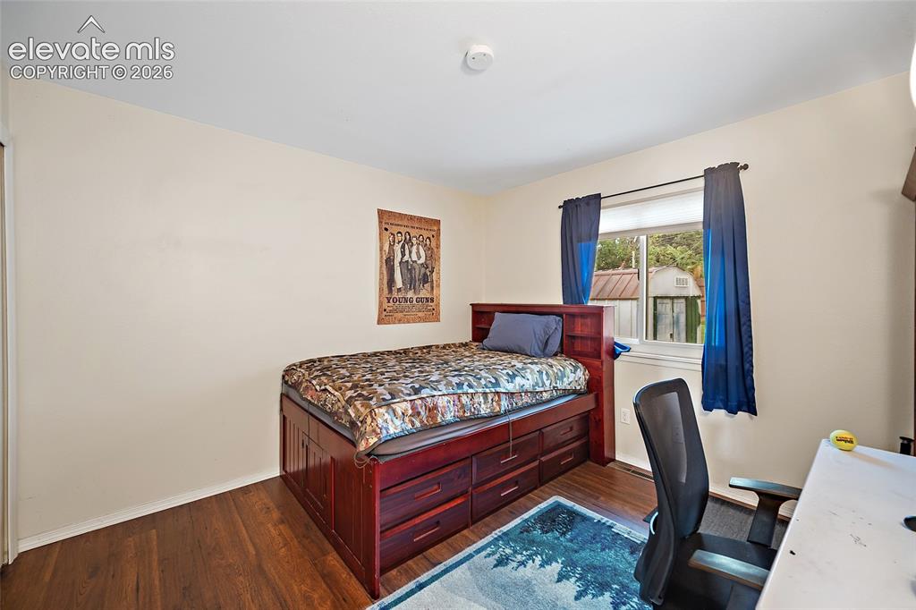 Image 16 of 44: Bedroom featuring wood-finish flooring, light neutral walls, and a window w