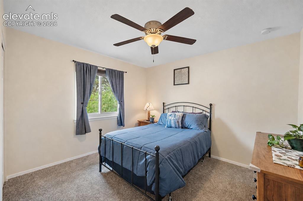 Image 19 of 44: Bedroom featuring a ceiling fan with integrated lighting, a window with ext