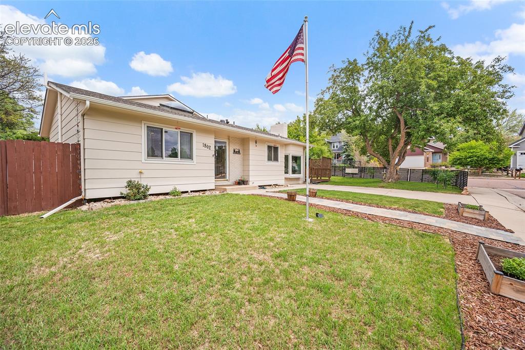Image 2 of 44: Ranch-style exterior with beige siding and a dark brown fence
