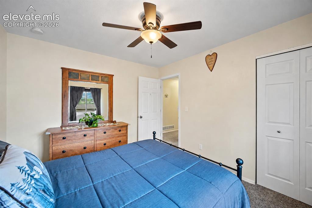 Image 20 of 44: Bedroom featuring a ceiling fan, dual bi-fold closet doors, and light-color