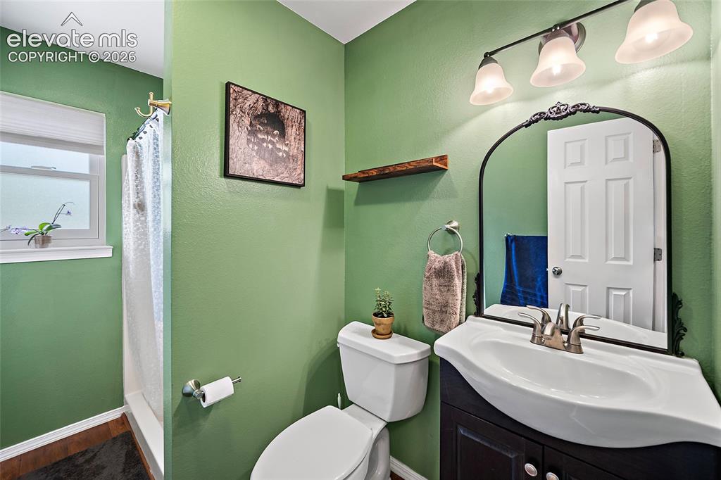 Image 21 of 44: Bathroom featuring a dark wood-finish vanity with an integrated sink, an ar