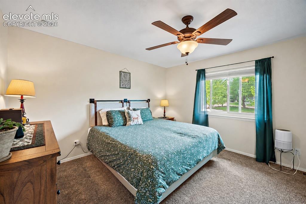 Image 22 of 44: Carpeted room featuring a ceiling fan with integrated lighting, a window wi