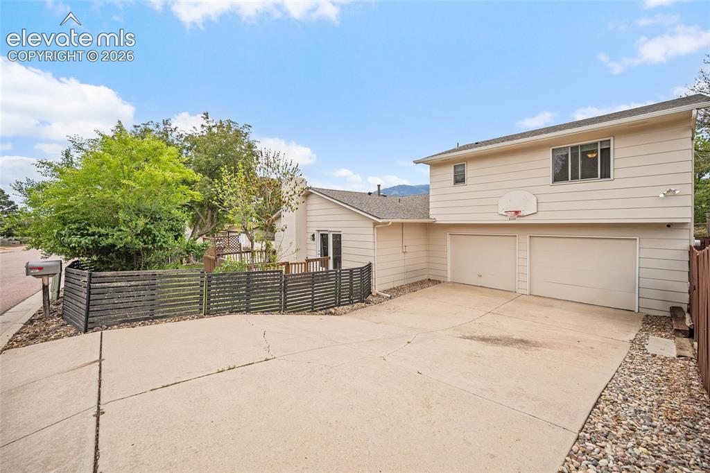 Image 29 of 44: Two-story exterior with light-colored siding, a two-car garage, and a concr