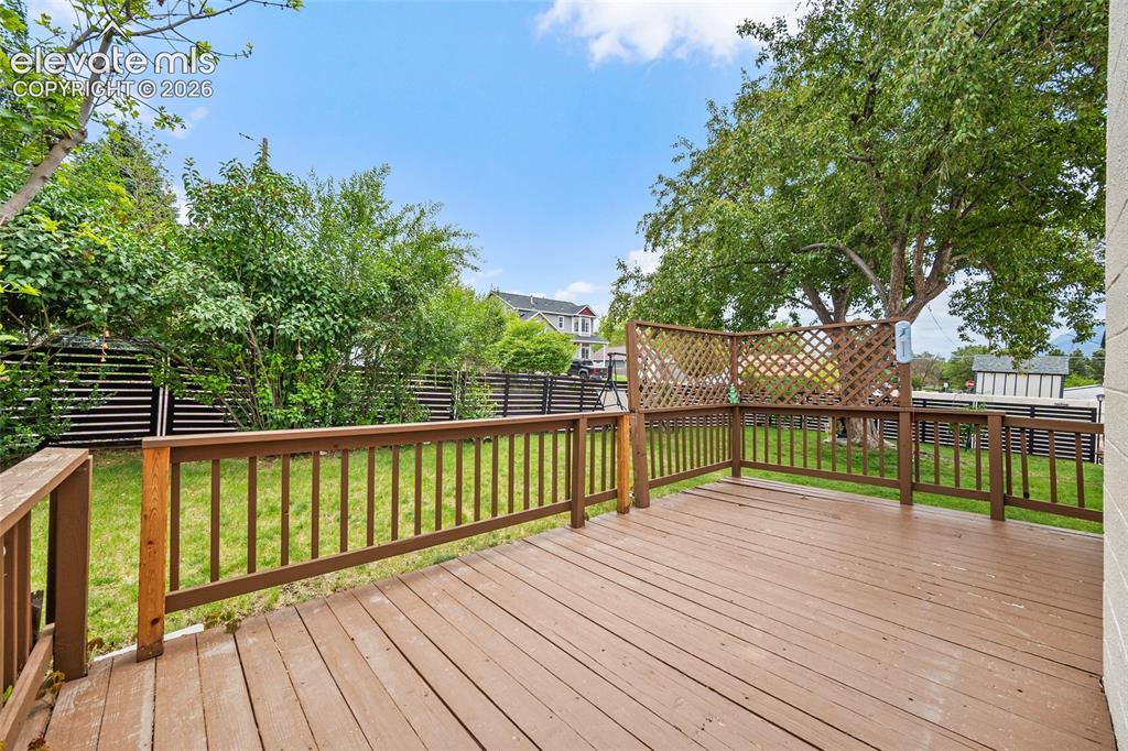 Image 31 of 44: Expansive wood-finish deck featuring a lattice privacy screen and full peri