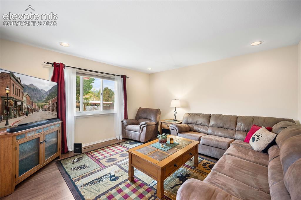 Image 4 of 44: Living area featuring wood-finish flooring, recessed lighting, and a window