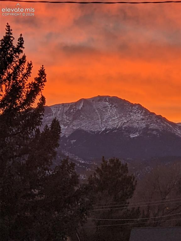 Image 43 of 44: Mountain backdrop featuring snow-capped peaks and a vibrant orange sky