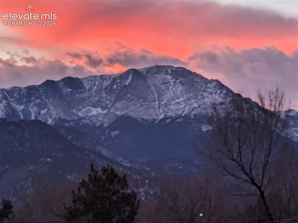 Image 44 of 44: Snow-capped mountain range under a vibrant, cloud-filled sky