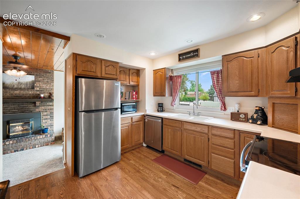 Image 8 of 44: Kitchen featuring wood-finish flooring, oak cabinetry, white countertops, a