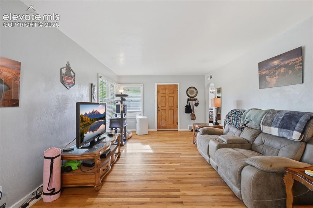Image 10 of 32: Light-toned wood-finish flooring, light grey wall paint, and a paneled wood
