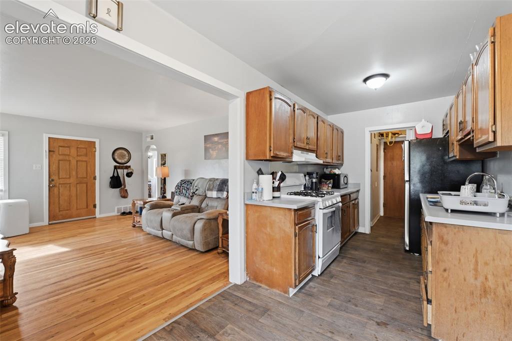 Image 12 of 32: Kitchen with wood cabinetry, light countertops, and wood-finish flooring