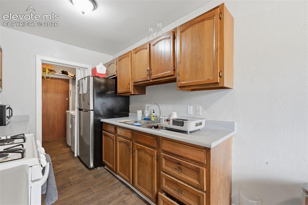 Image 13 of 32: Kitchen featuring wood-finish cabinetry, light-toned countertops, and wood-