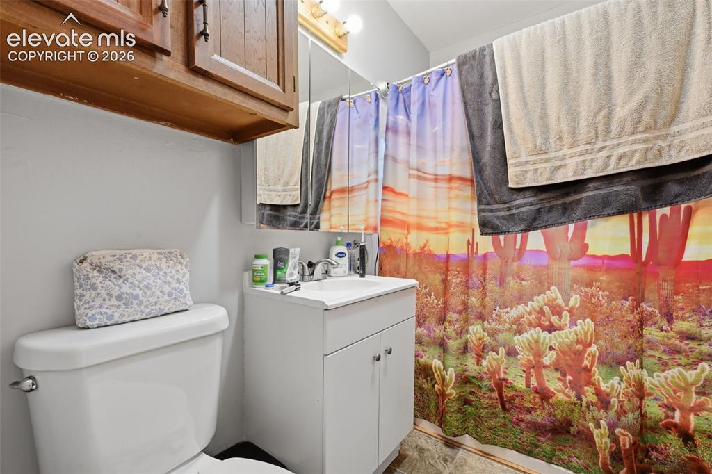 Image 18 of 32: White vanity with integrated sink, chrome faucet, and cabinet storage