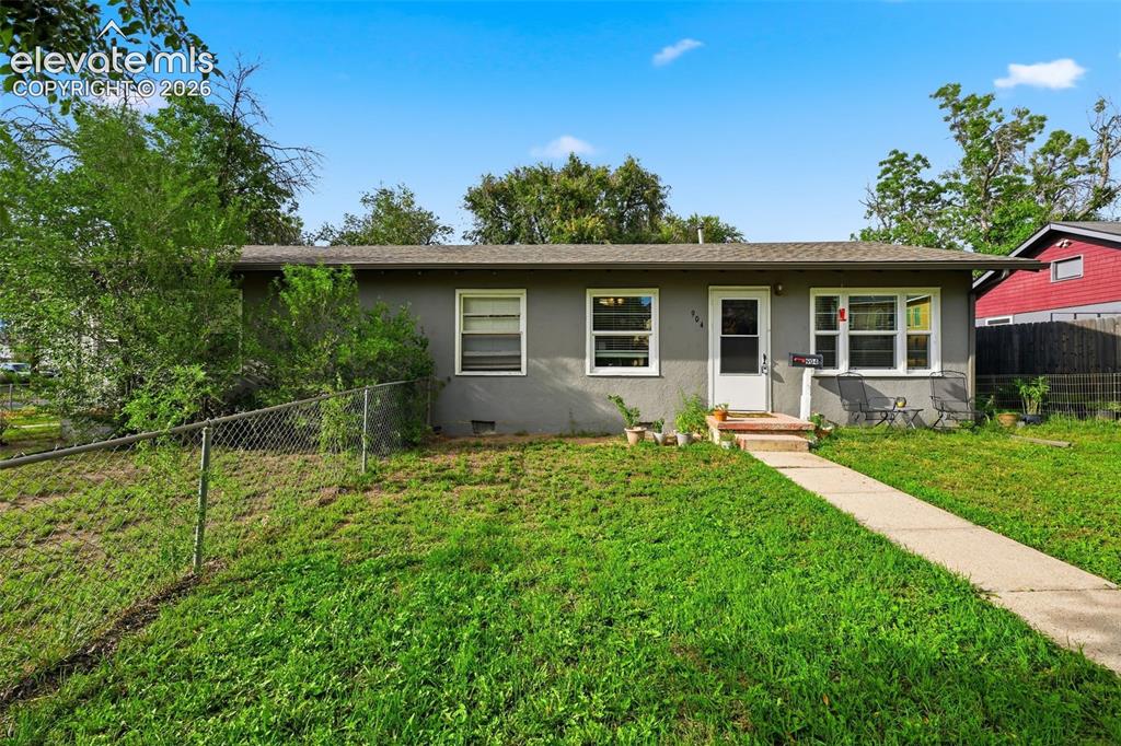 Image 2 of 32: Single-story residence featuring a gray exterior and white window trim