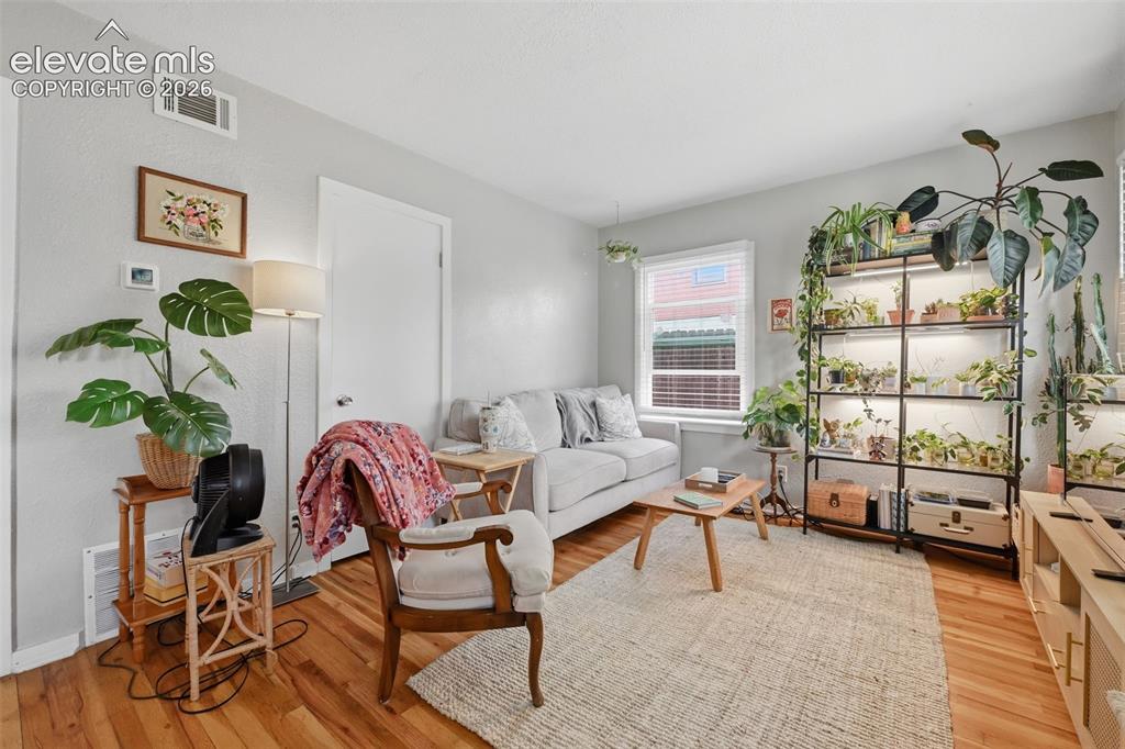 Image 21 of 32: Wood-finish flooring, light grey wall paint, and a window with blinds