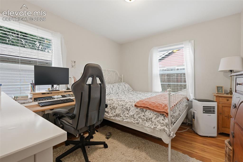 Image 24 of 32: Hardwood flooring, painted walls, and window treatments