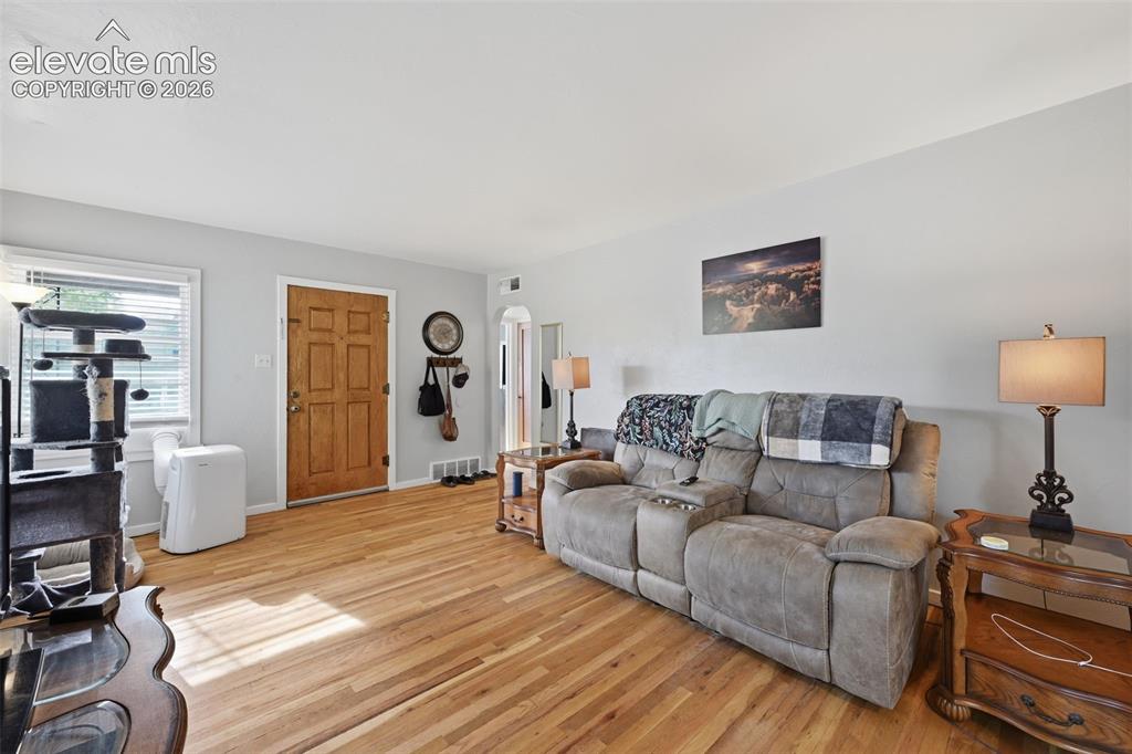 Image 9 of 32: Hardwood flooring throughout, light gray wall paint, white trim, and a pane