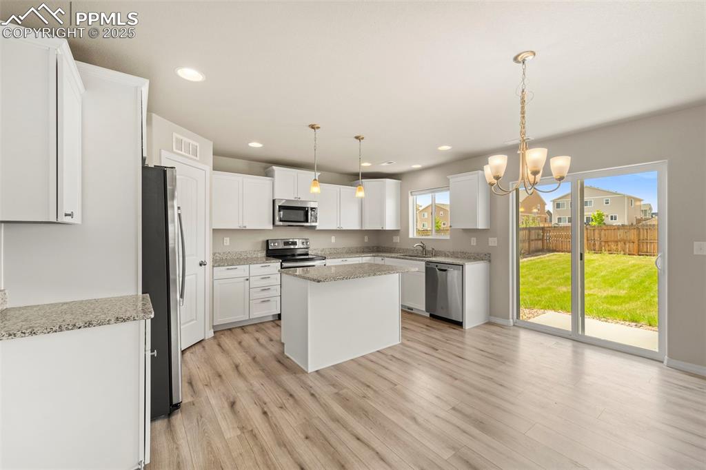 Image 18 of 35: Kitchen featuring stainless steel appliances, light wood finished floors, a