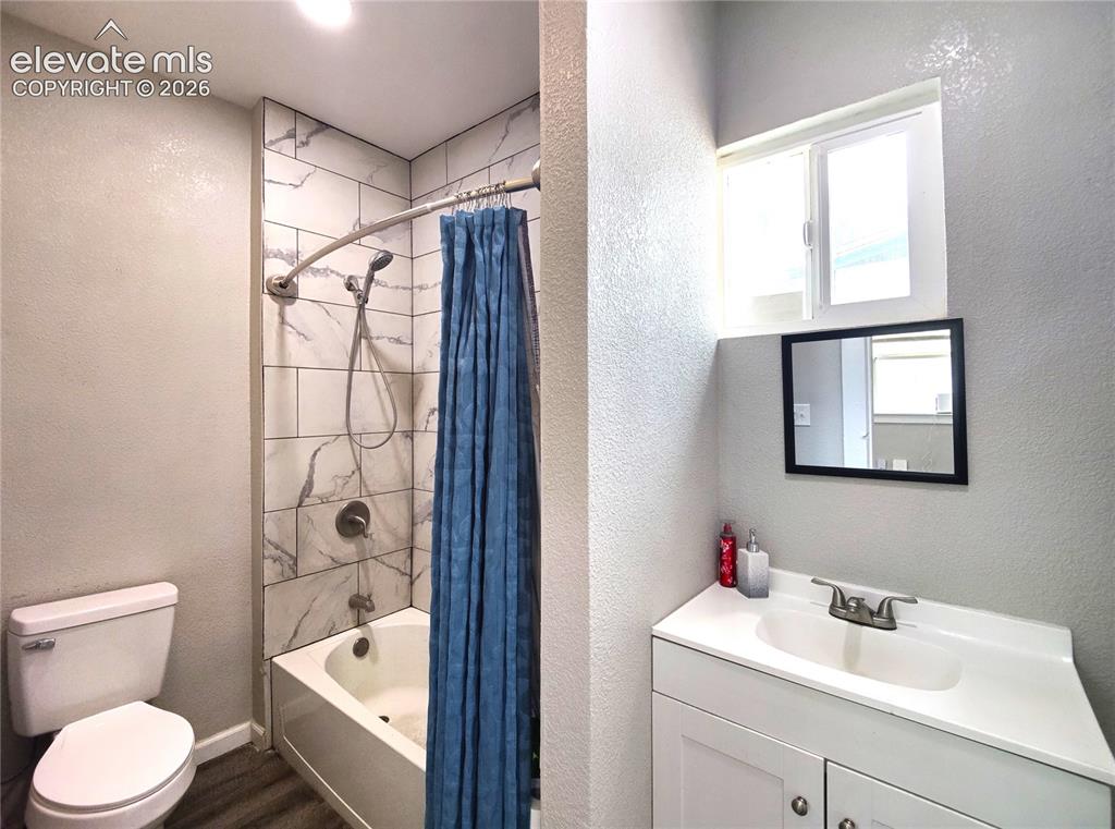 Image 10 of 13: Bathroom featuring a white vanity with integrated sink, a rectangular mirro