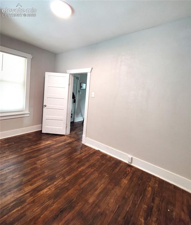 Image 9 of 13: Rich wood-finish flooring with white trim, a flush-mount ceiling light, and