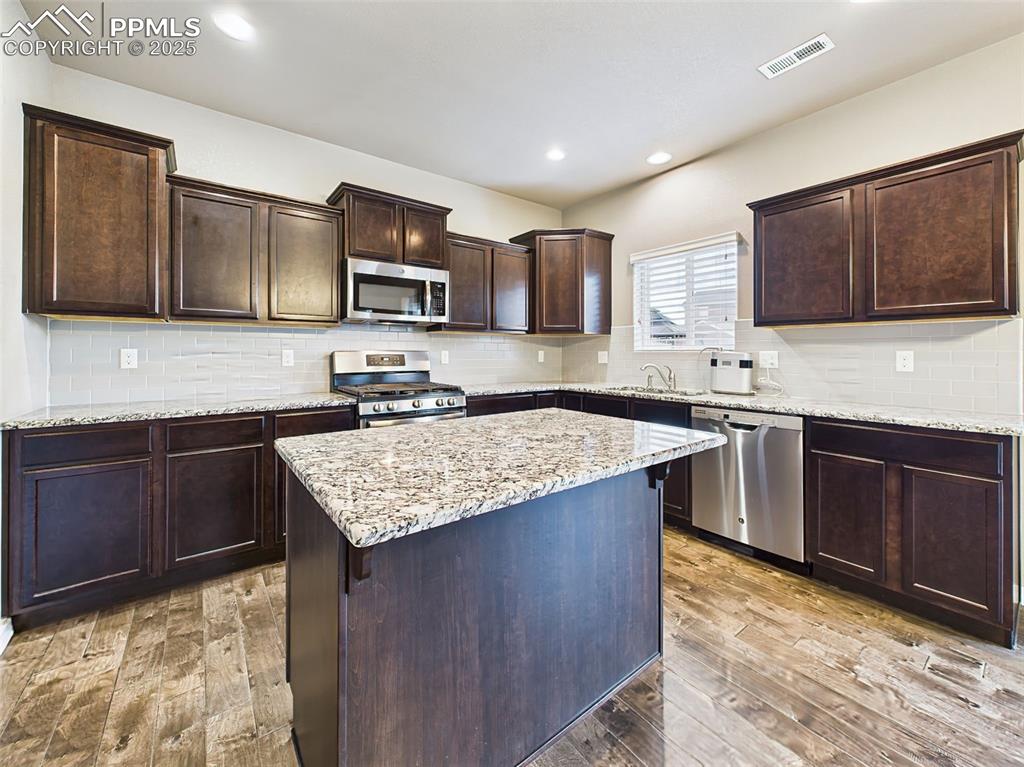 Image 17 of 50: Another view of the spacious center island and surrounding cabinetry, offer