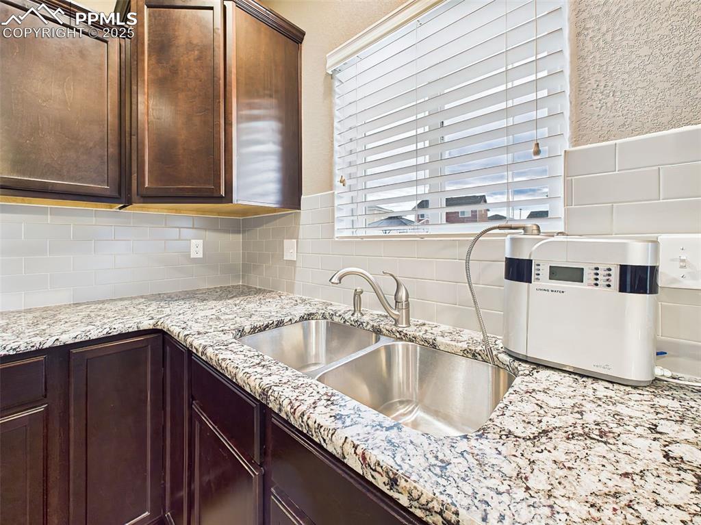 Image 18 of 50: Close-up of the undermount double sink with pull-down faucet, granite count
