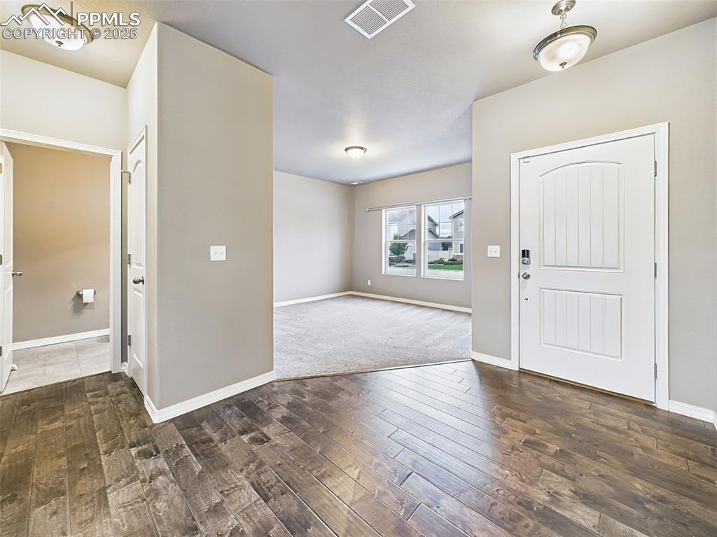 Image 2 of 50: Bright and open foyer with LVP flooring looks like rich hardwood flooring a