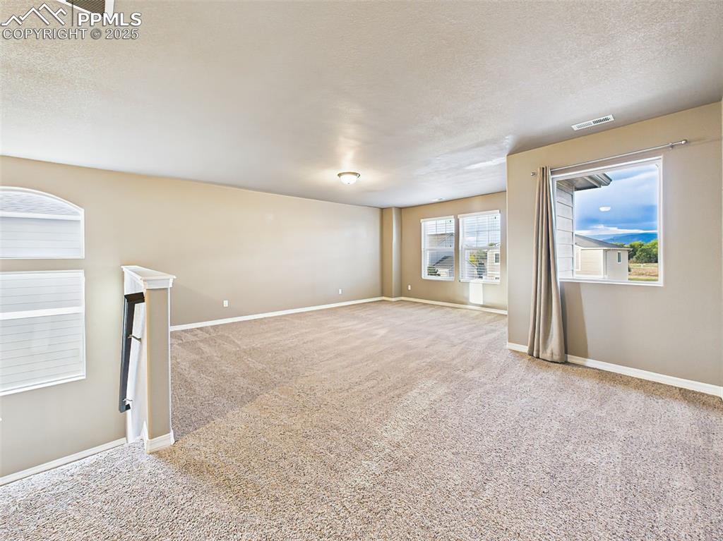 Image 20 of 50: Expansive upstairs loft with multiple windows and mountain views—ideal for