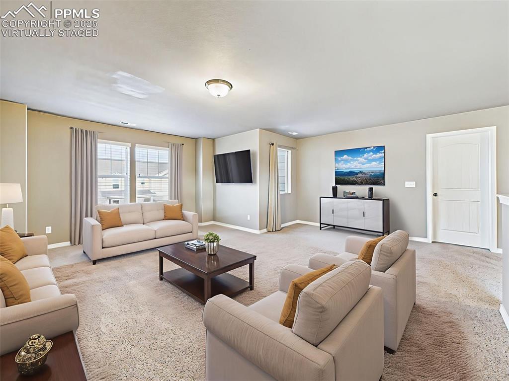 Image 22 of 50: Virtually staged - as a cozy media room with a full sofa set and entertainm