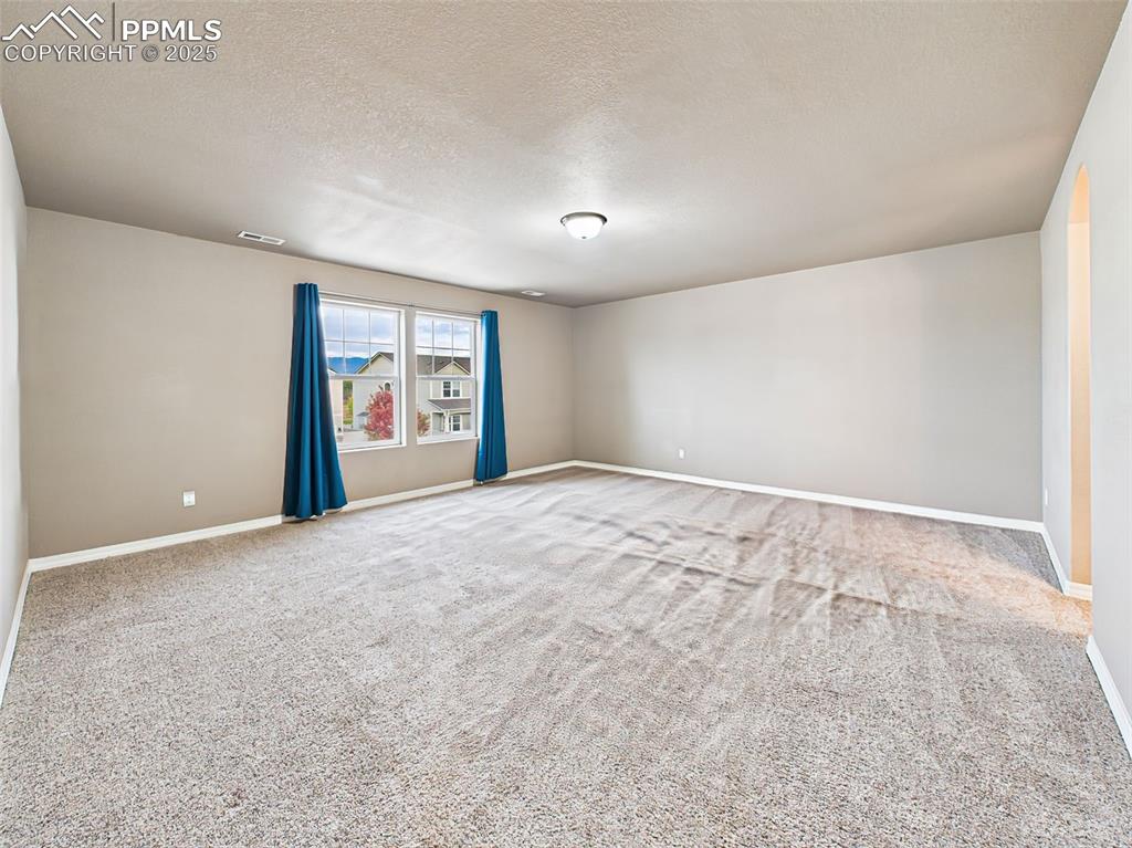 Image 25 of 50: Expansive primary suite with large windows, neutral tones, and plenty of sp