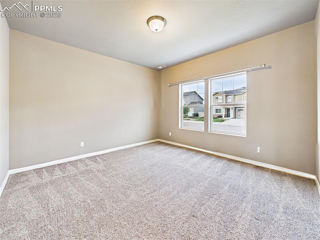 Image 3 of 50: Versatile space with large windows and plush carpet, ideal for a home offic