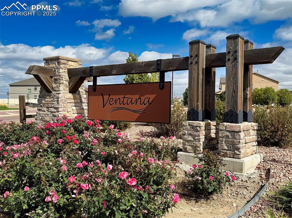 Image 40 of 50: Welcoming entry to the Ventana community, surrounded by blooming landscapin