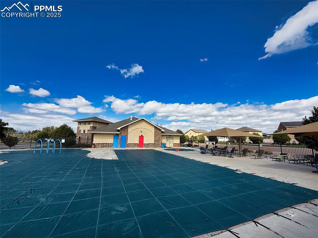 Image 49 of 50: Pool Area (Covered) – Outdoor community pool with shaded lounge area and wa