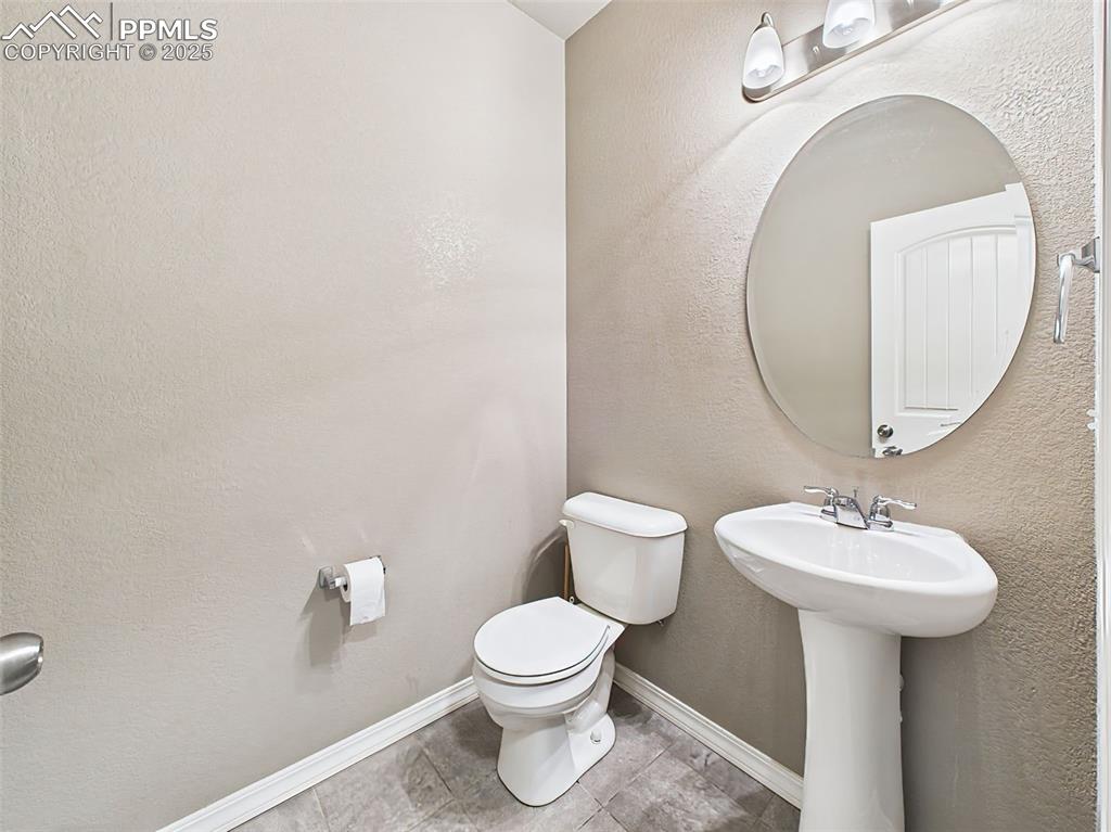 Image 5 of 50: Convenient main-level half bath with tile flooring and a pedestal sink.