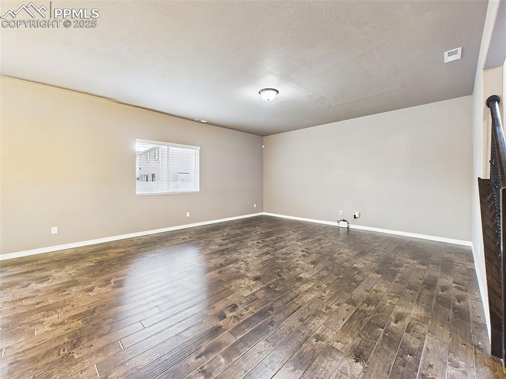 Image 7 of 50: Another view of the spacious living room highlighting multiple furniture la