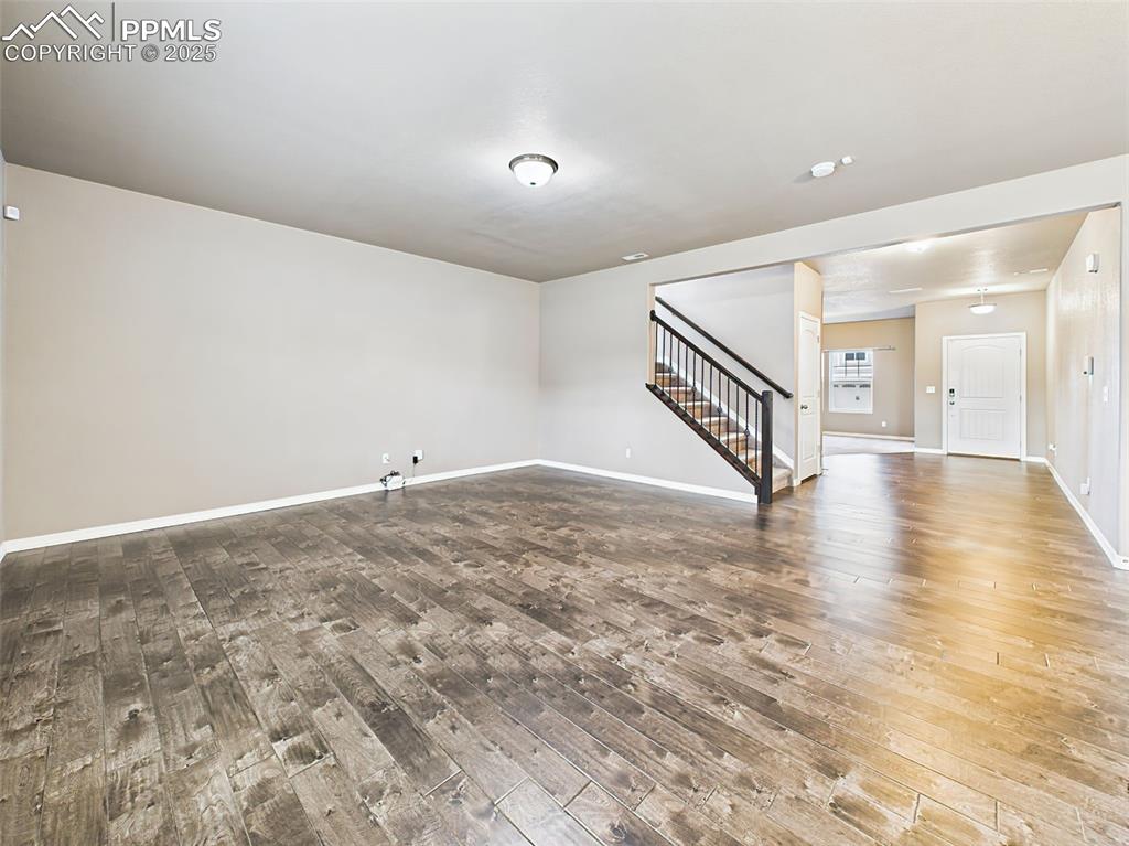 Image 9 of 50: Expansive living area with beautiful LVP floors, open layout, and a seamles