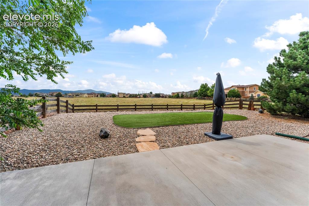 Image 29 of 36: Backyard with rock and turf.
