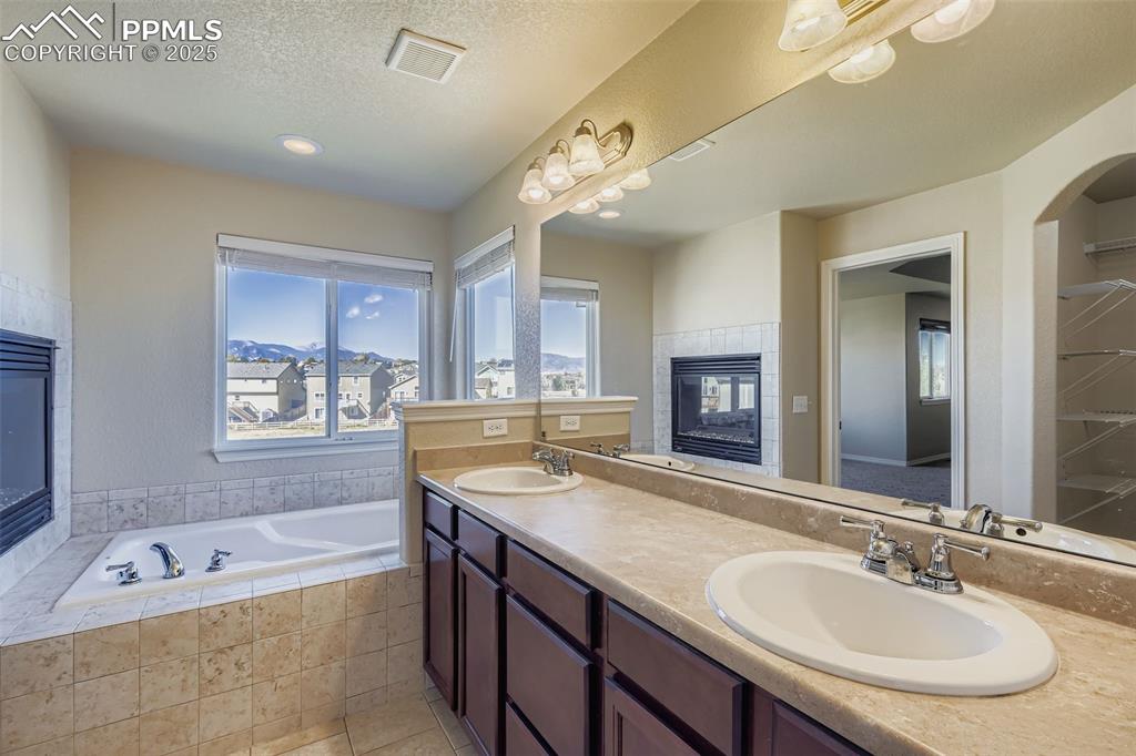 Image 18 of 49: Primary Bathroom double vanity, soaking tub with mountain views